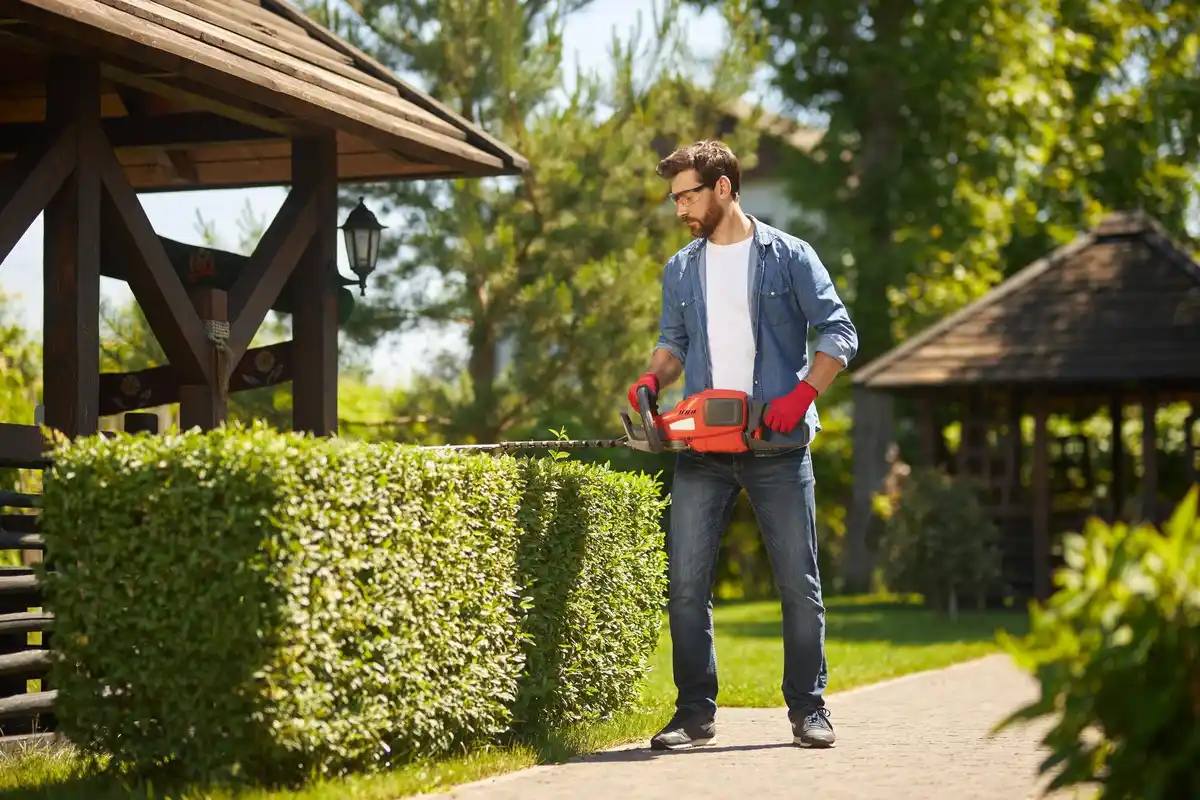 man cleaning garden tools in backyard spring