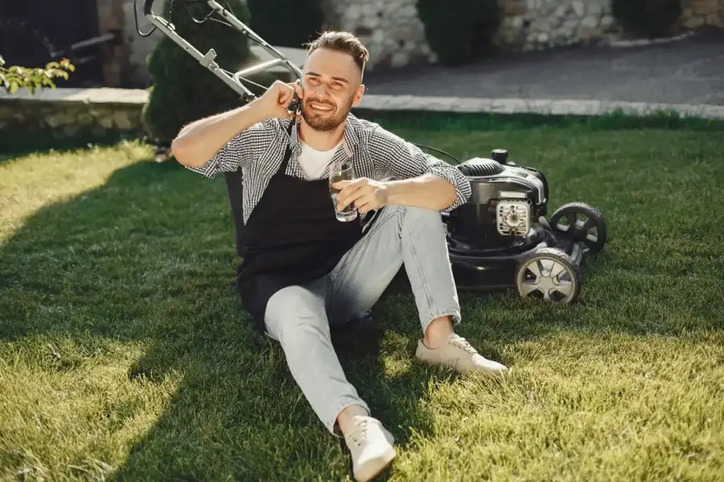 dutch gardener using manual lawn mower in garden