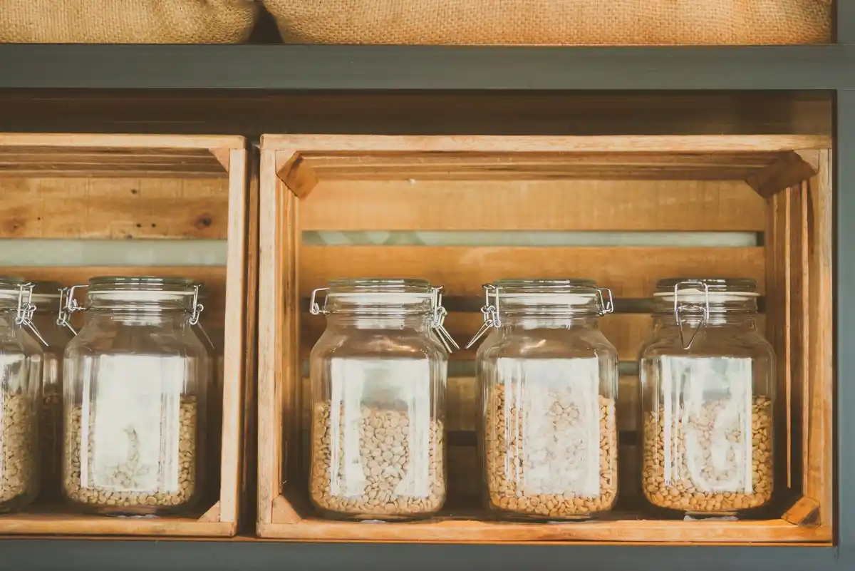 old seed packets and jars on wooden shelf in home gardening shed