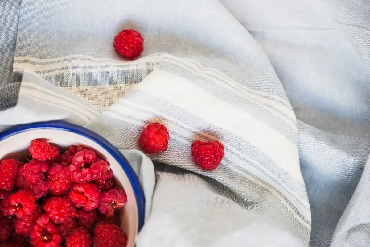 raspberries in a clay pot on a wooden table, Dutch garden