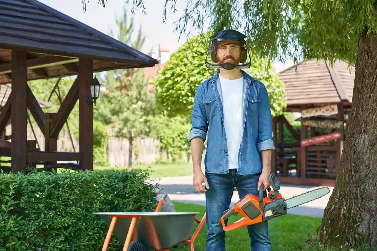 frustrated man watching broken robotic lawn mower in garden