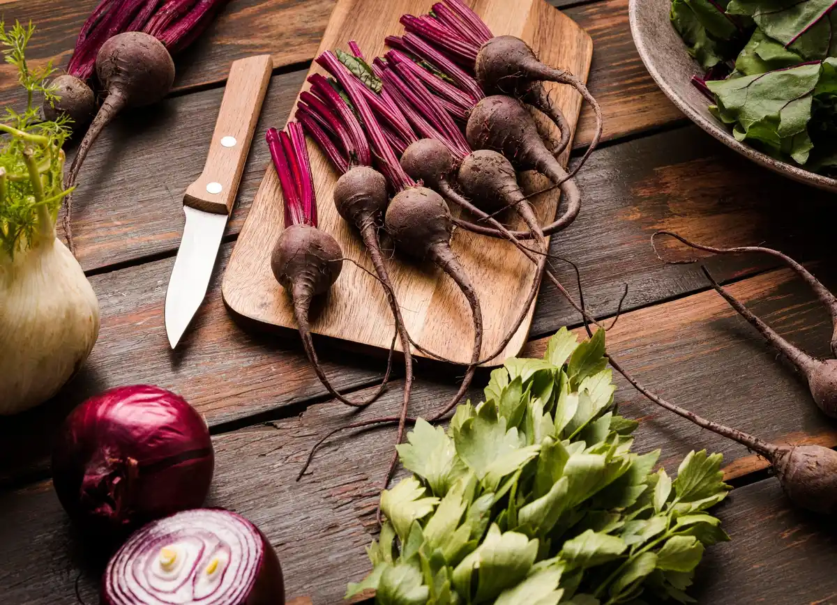 close up of carrots and beets stored in sand in cellar