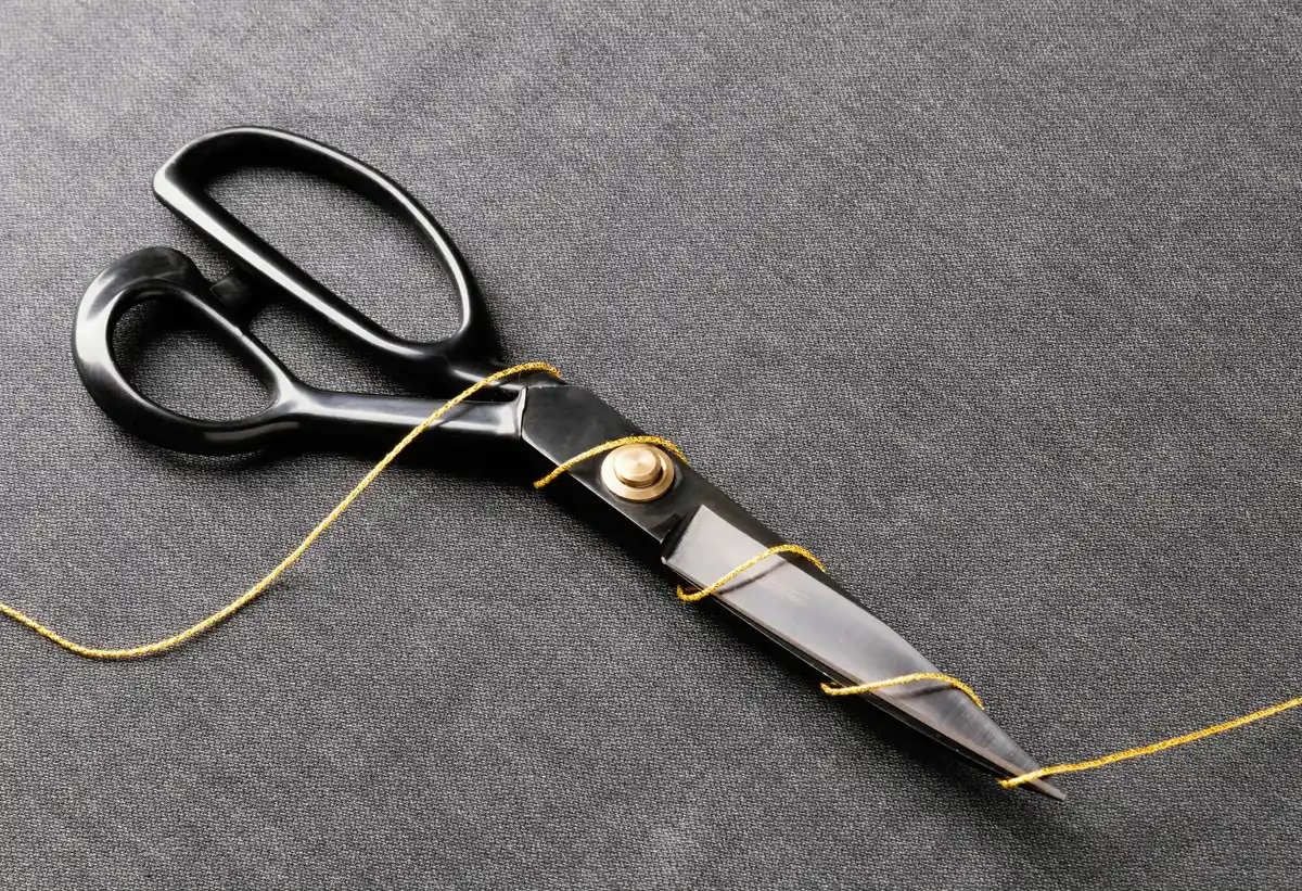 old fashioned textile scissors close up on fabric table